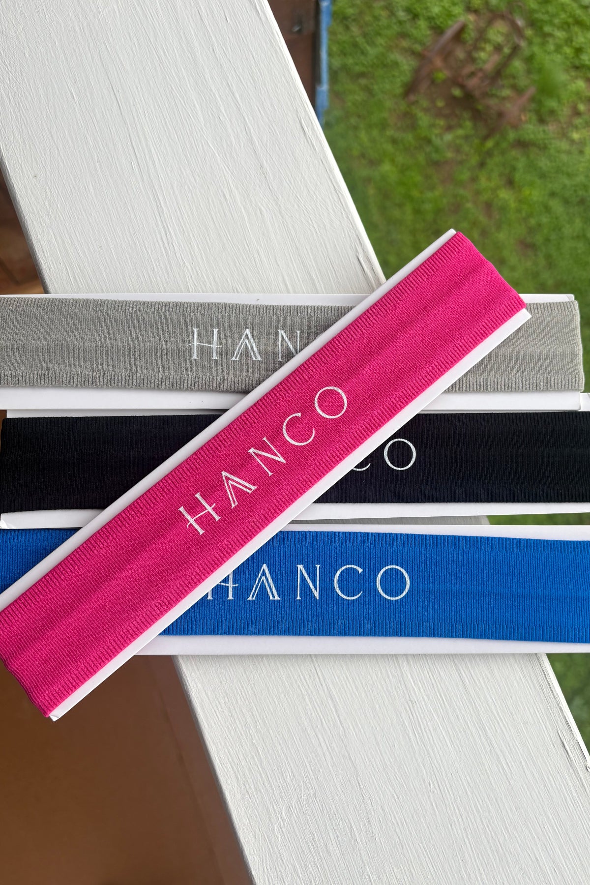 Four headbands with different colors on a white surface, with 'Hanco' branding.