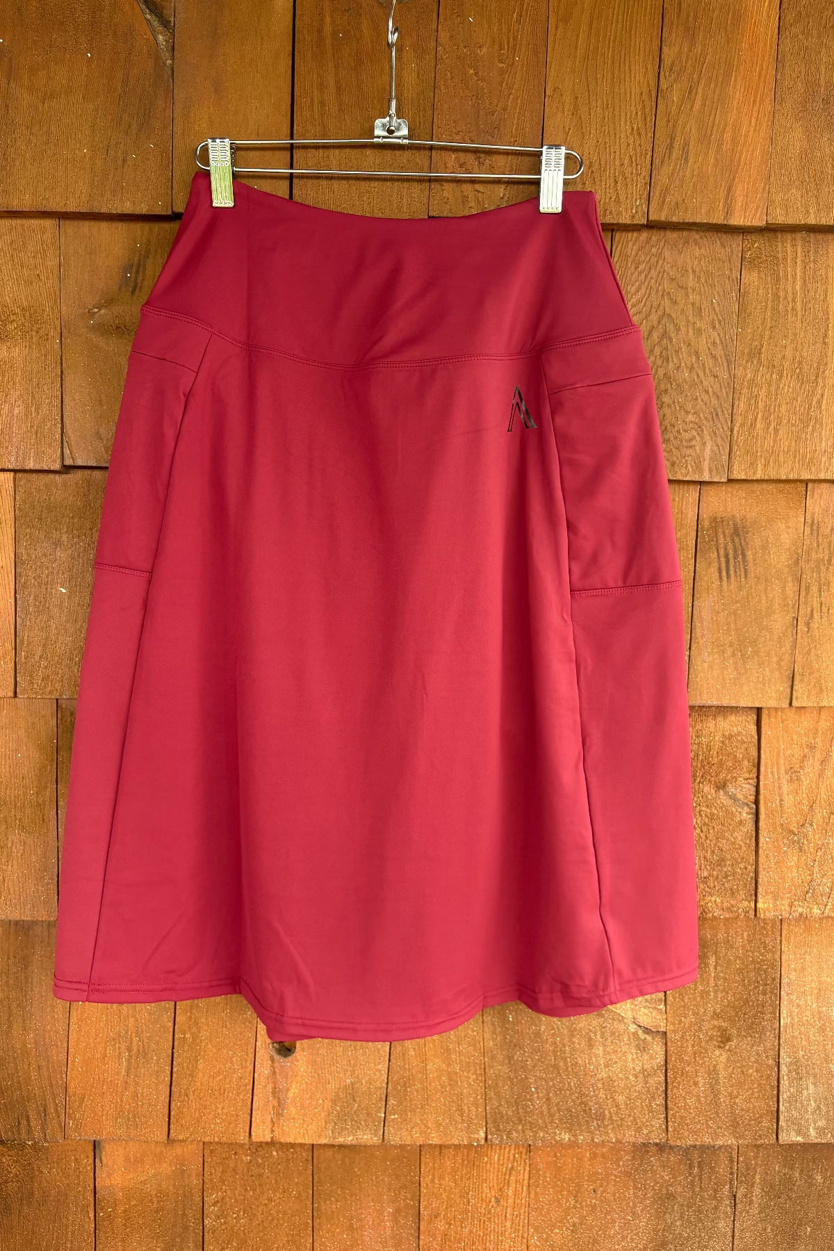 Red skirt hanging on a wooden wall