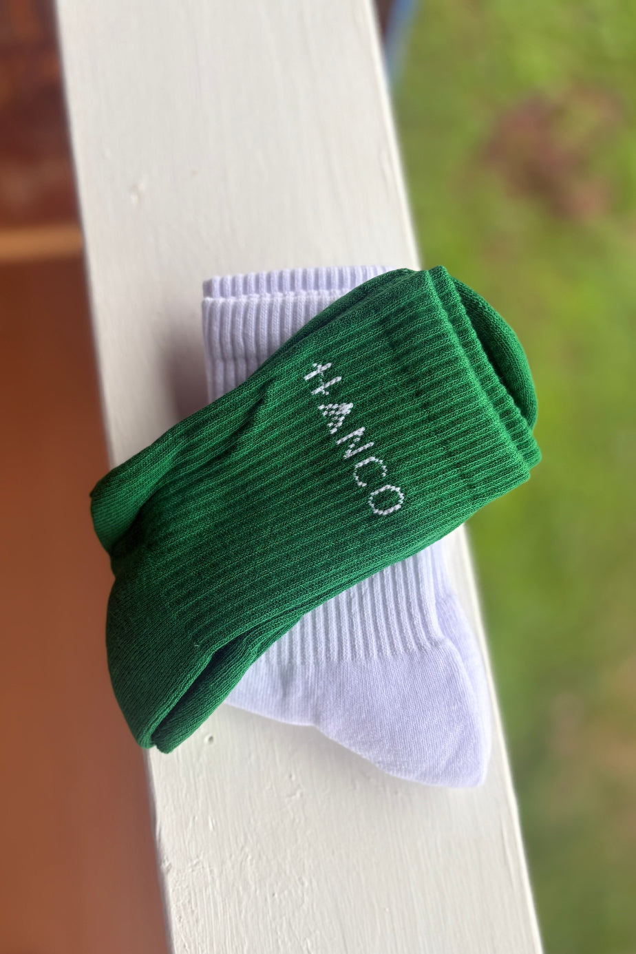 Green and white socks with 'HANCO' branding on a white surface.