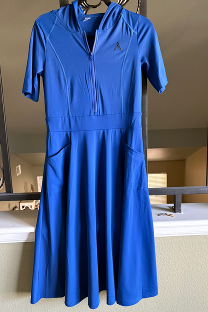 Blue dress hanging on a hanger in front of a mirror.