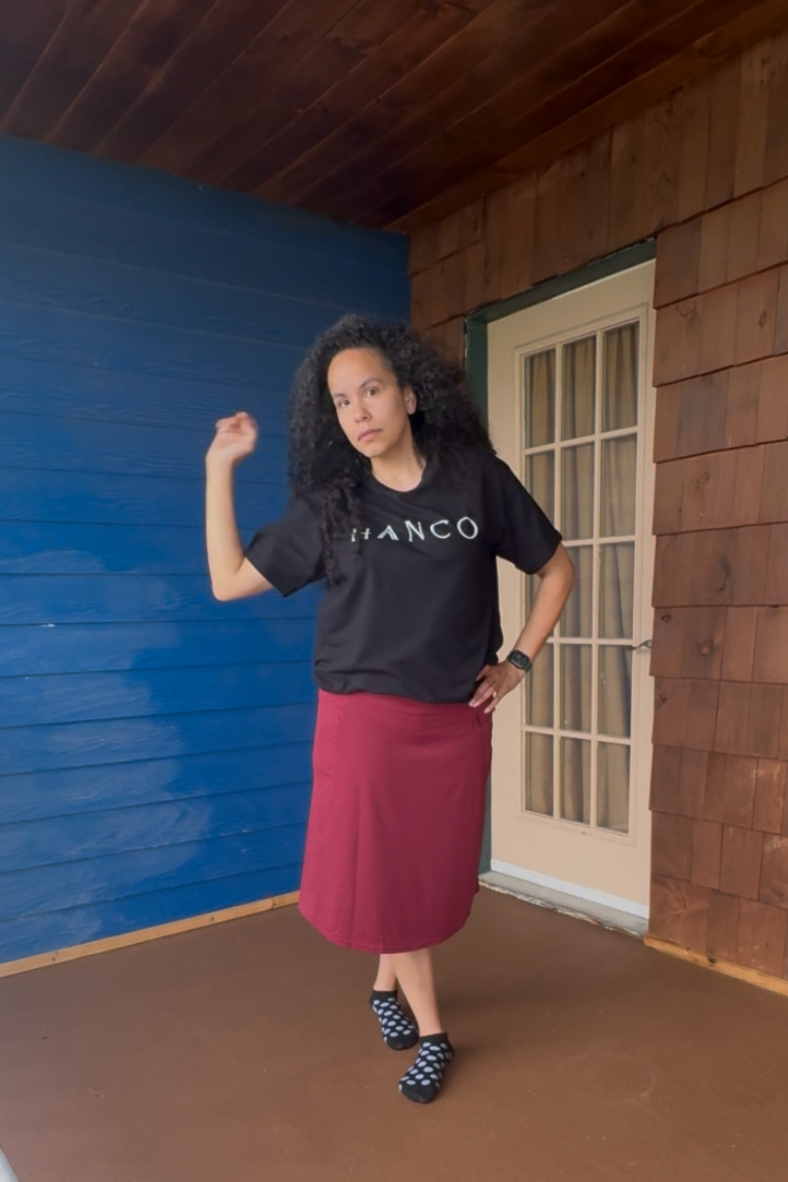 Person standing on a wooden deck with a blue wall and white door in the background