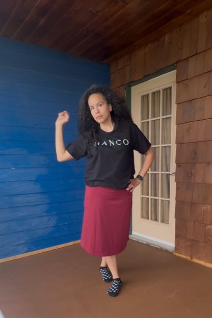 Person standing on a wooden deck with a blue wall and white door in the background